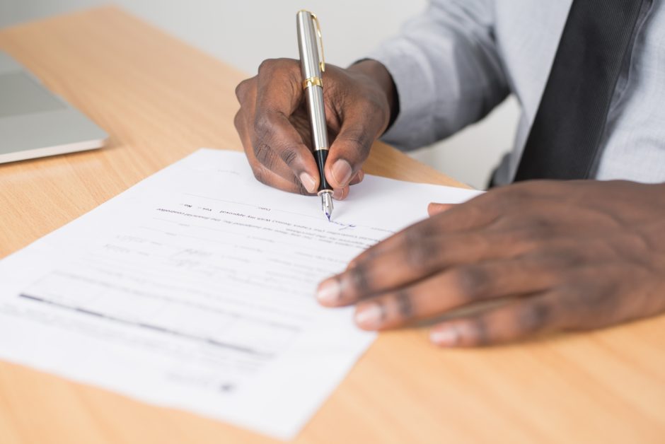 hands holding a pen signing a contract