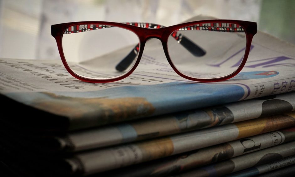 glasses on newspapers